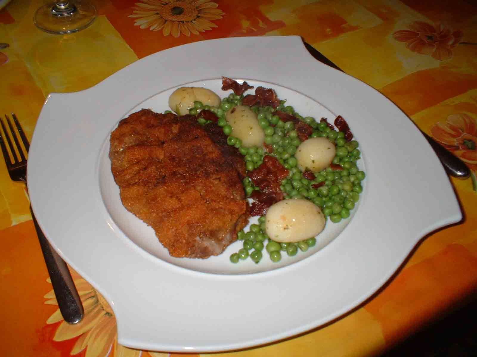 Paniertes Nackensteak mit Butterkartoffeln an Erbsen mit Speck